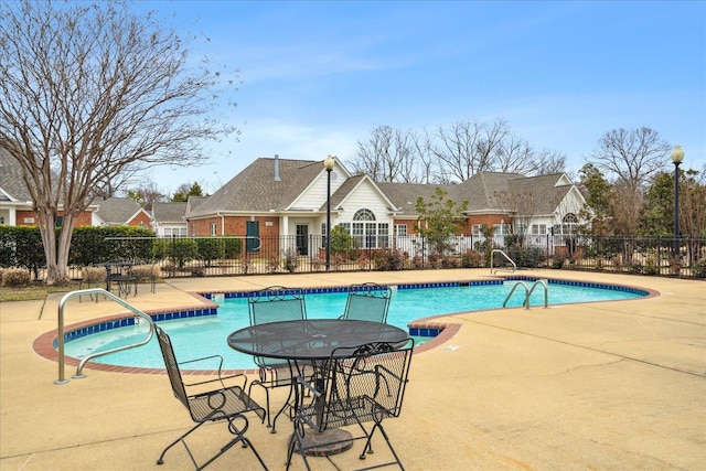 pool with a patio area and fence