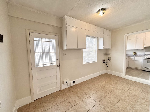 interior space with laundry area, baseboards, washer hookup, and a textured ceiling