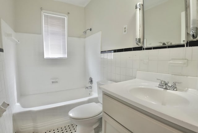 full bathroom featuring toilet, bathtub / shower combination, tile walls, and vanity