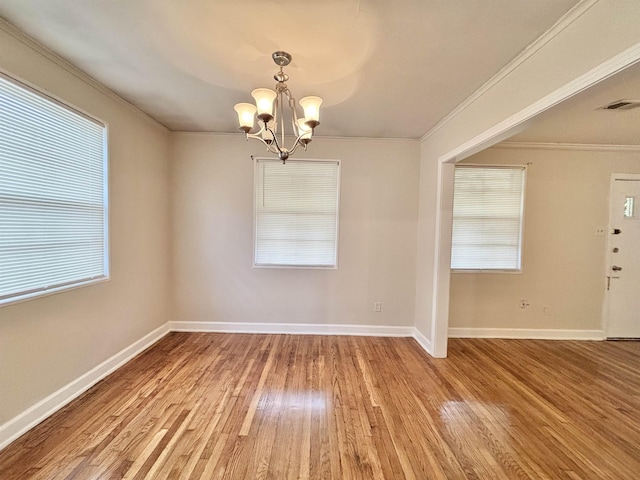 unfurnished room with ornamental molding, wood finished floors, visible vents, and a notable chandelier