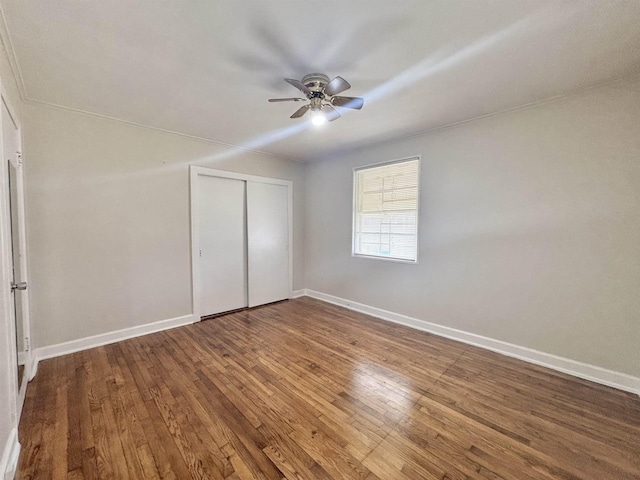 unfurnished bedroom featuring a ceiling fan, a closet, baseboards, and hardwood / wood-style floors