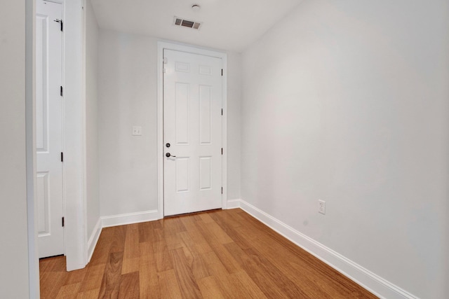 interior space featuring baseboards, visible vents, and light wood-style floors