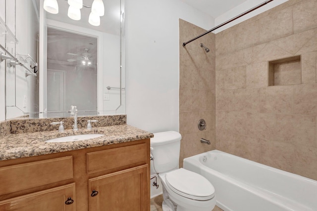 bathroom with bathtub / shower combination, ceiling fan, vanity, and toilet