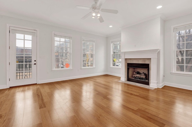 unfurnished living room with plenty of natural light, wood finished floors, and crown molding