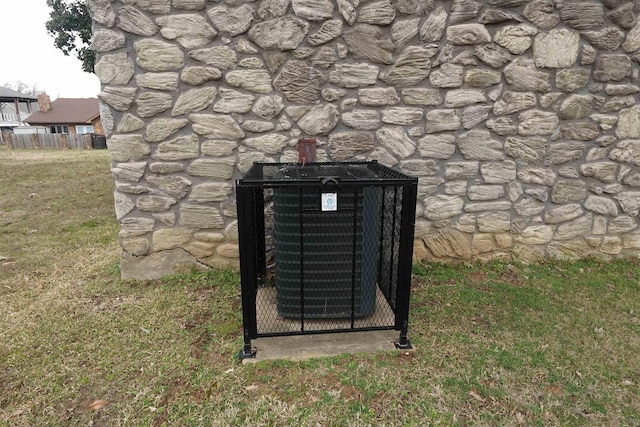 details featuring stone siding and central AC unit