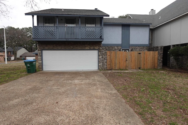 view of front facade with stucco siding, concrete driveway, an attached garage, a balcony, and stone siding