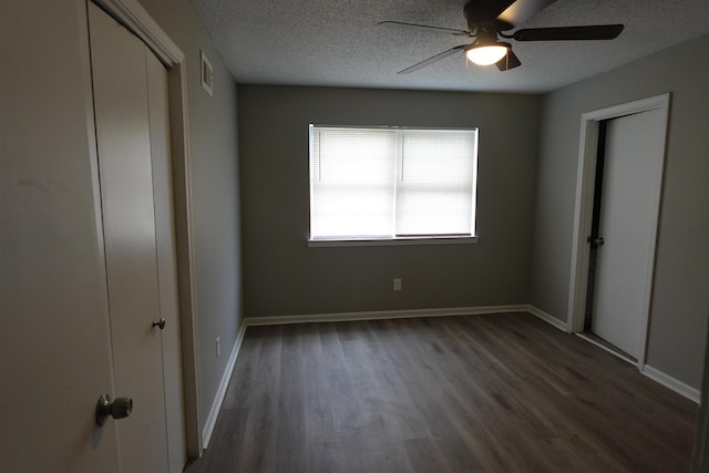 unfurnished bedroom featuring baseboards, visible vents, a ceiling fan, wood finished floors, and a textured ceiling