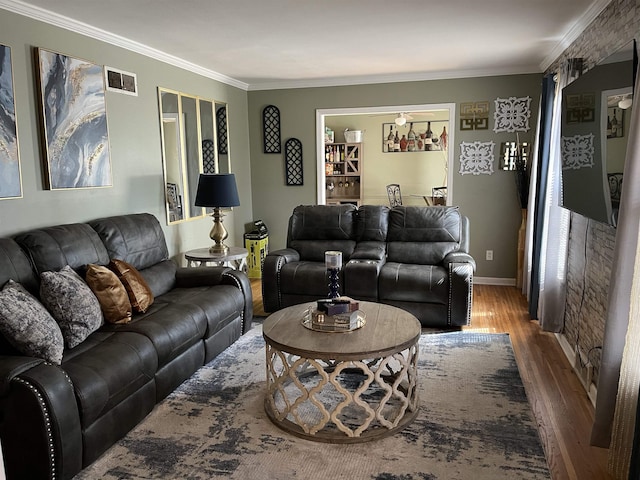 living room featuring visible vents, crown molding, baseboards, and wood finished floors