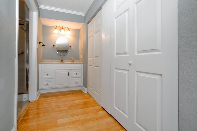 corridor featuring light wood-style flooring and crown molding