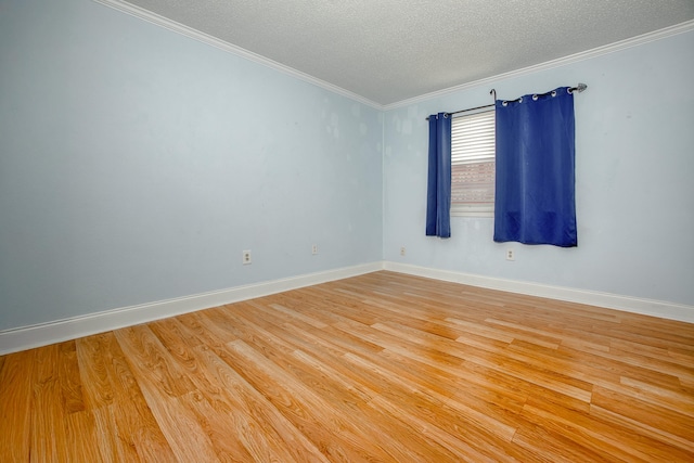 unfurnished room with light wood-type flooring, crown molding, a textured ceiling, and baseboards