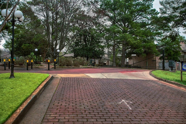 exterior space with community basketball court, a lawn, and fence