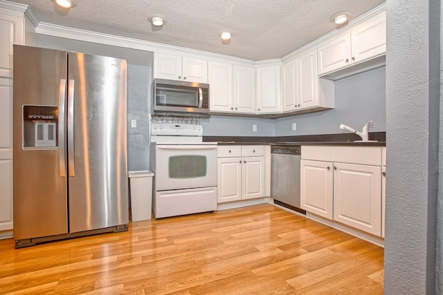 kitchen featuring stainless steel appliances, light wood-type flooring, and white cabinets