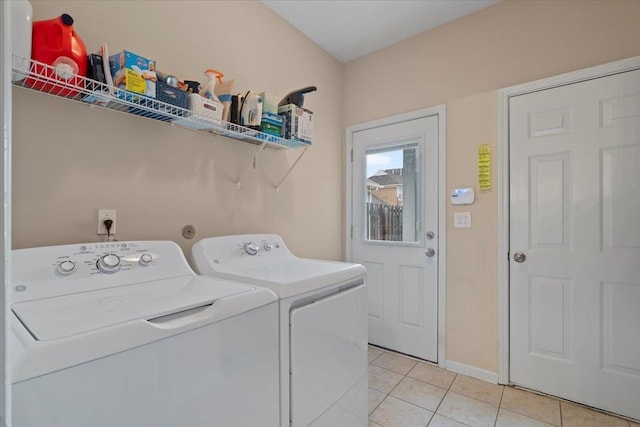 laundry area with light tile patterned floors, laundry area, washer and clothes dryer, and baseboards