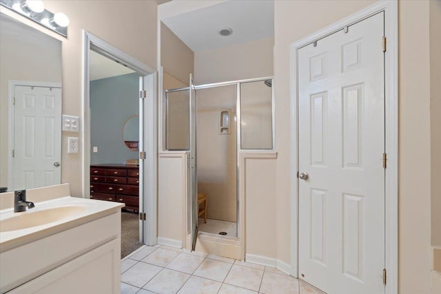 full bathroom with a stall shower, vanity, and tile patterned floors