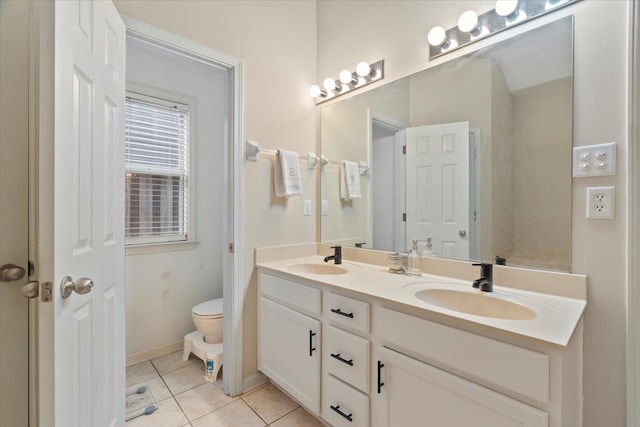 full bath featuring double vanity, tile patterned flooring, a sink, and toilet