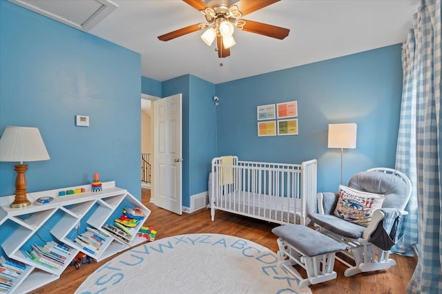 bedroom with wood finished floors, a ceiling fan, and baseboards