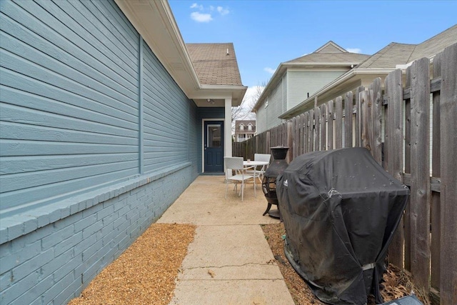 view of patio featuring a grill and fence