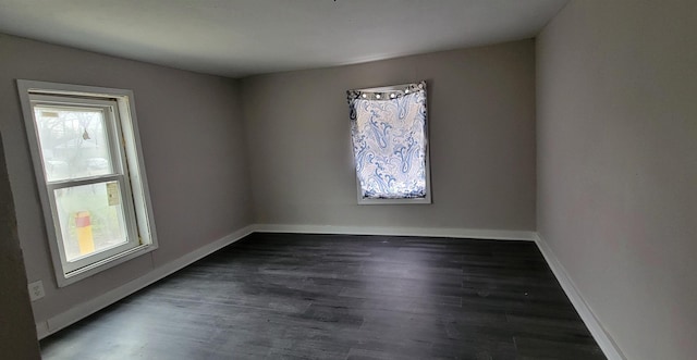 unfurnished room with baseboards and wood finished floors