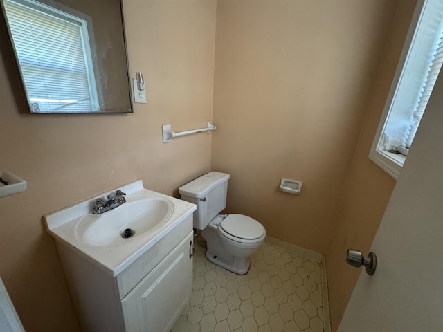 bathroom with tile patterned floors, vanity, toilet, and baseboards