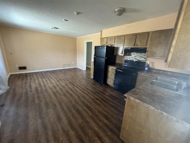 kitchen featuring under cabinet range hood, a sink, baseboards, dark wood-style floors, and black appliances