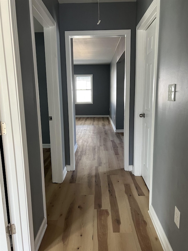 hallway with baseboards and wood finished floors