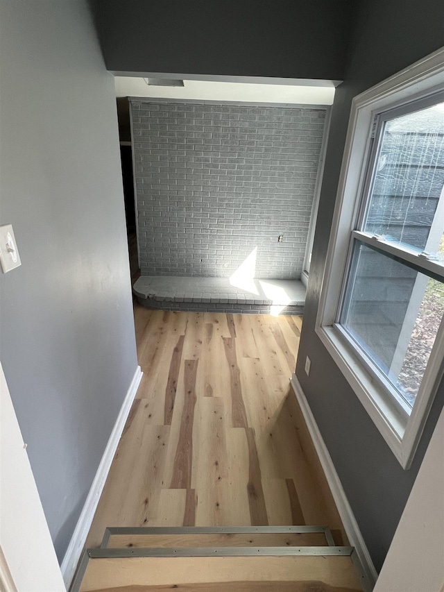 hallway featuring baseboards and wood finished floors