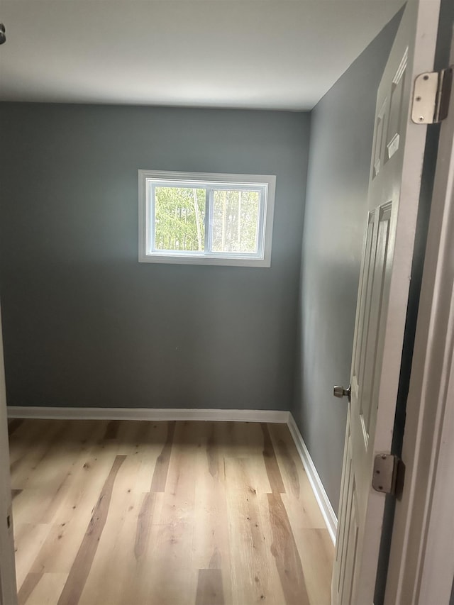 empty room with light wood finished floors and baseboards