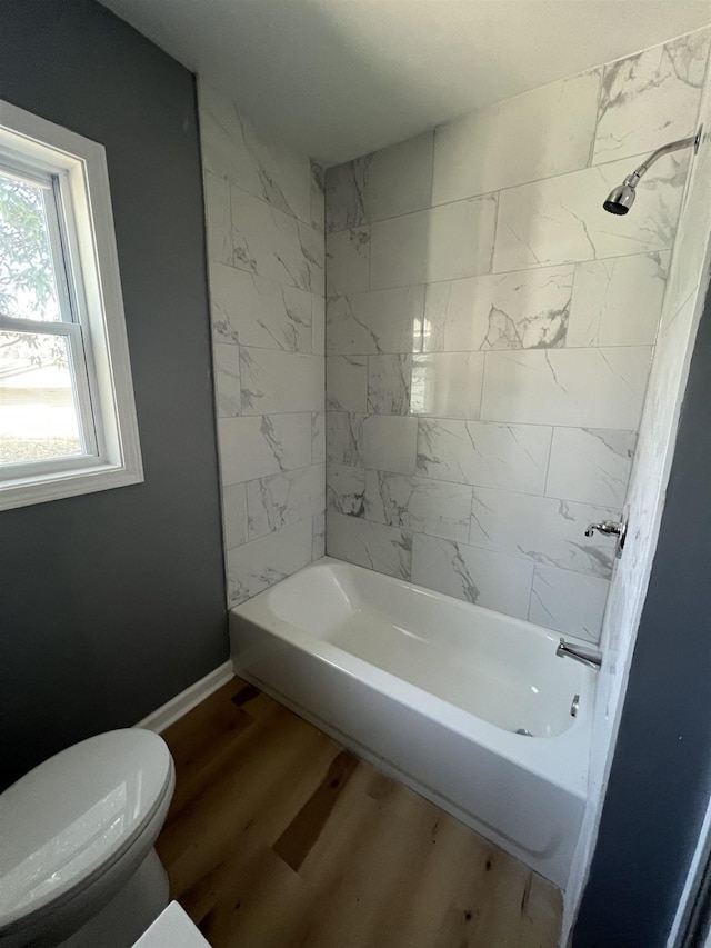 full bathroom with toilet, baseboards,  shower combination, and wood finished floors