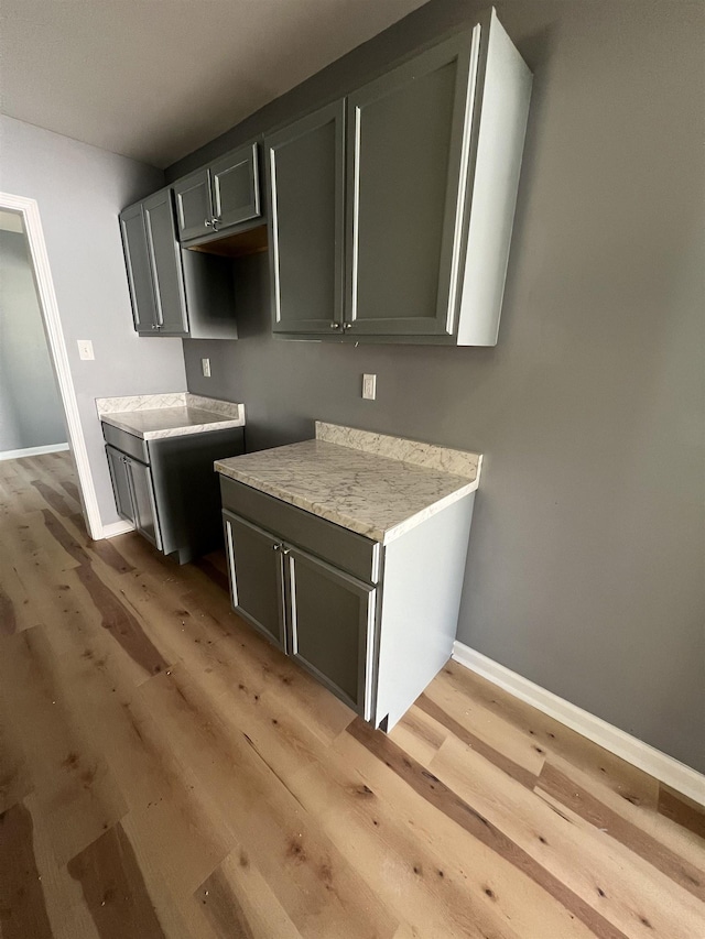 kitchen with light countertops, light wood-style flooring, and baseboards