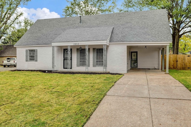 view of front of house featuring a shingled roof, brick siding, driveway, and a front lawn