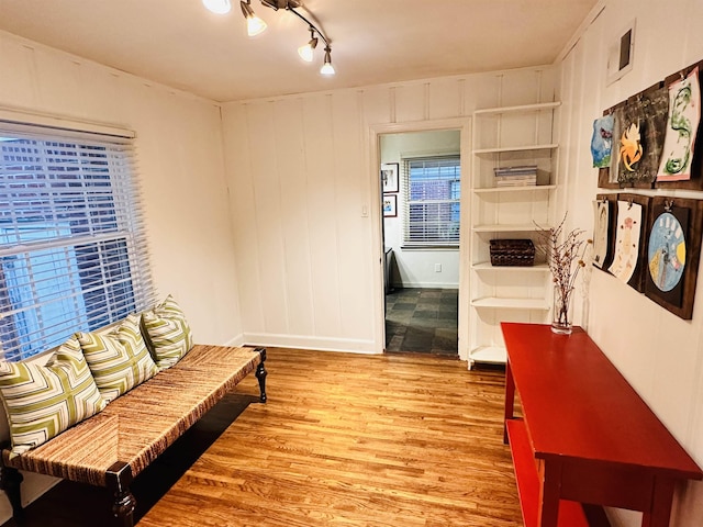 living area with visible vents, track lighting, baseboards, and wood finished floors