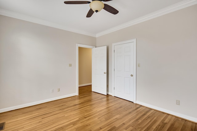 empty room with visible vents, crown molding, baseboards, light wood-style flooring, and a ceiling fan