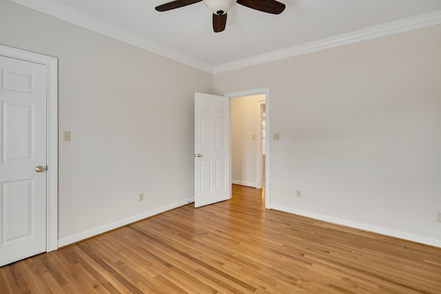 unfurnished room featuring light wood-style floors, baseboards, and ornamental molding