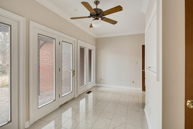 empty room featuring marble finish floor, a ceiling fan, crown molding, and baseboards