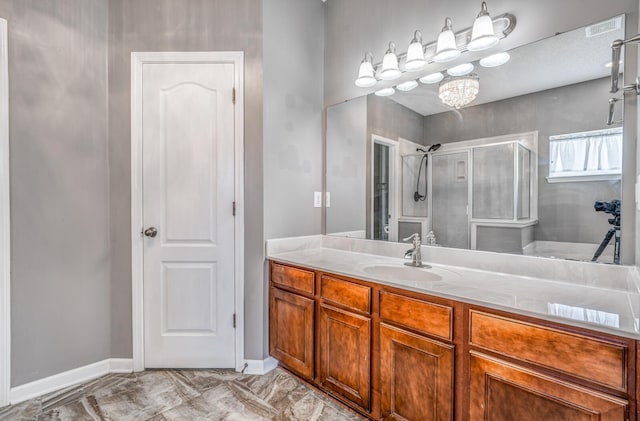 full bath with a shower with door, baseboards, a notable chandelier, and vanity