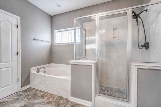 bathroom featuring a bath, baseboards, and a stall shower