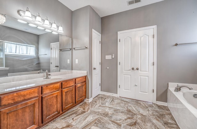 full bathroom featuring visible vents, a garden tub, marble finish floor, baseboards, and vanity