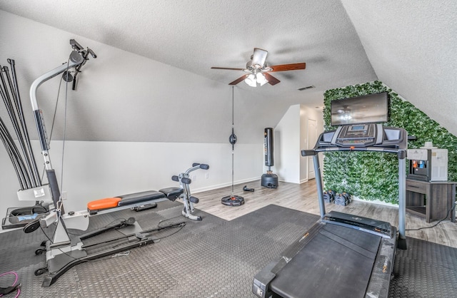 exercise area with visible vents, ceiling fan, lofted ceiling, wood finished floors, and a textured ceiling