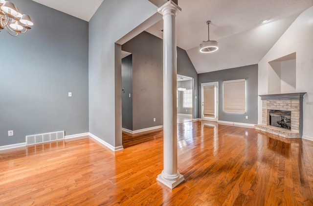 unfurnished living room featuring decorative columns, baseboards, visible vents, and light wood-type flooring