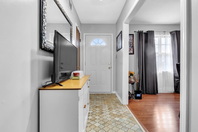 entrance foyer featuring visible vents, light wood-style floors, and baseboards