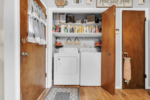 laundry room featuring laundry area, wood finished floors, separate washer and dryer, and visible vents