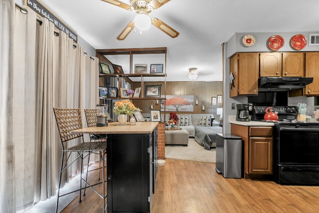 kitchen featuring a ceiling fan, electric range, light wood-style flooring, light countertops, and under cabinet range hood