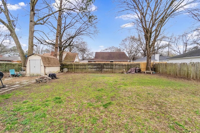 view of yard with a storage shed, an outbuilding, and a fenced backyard