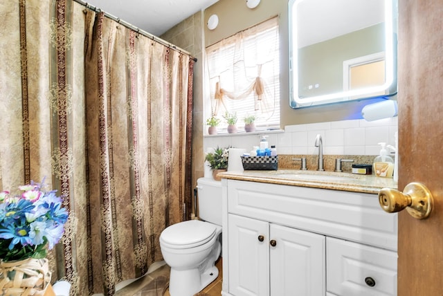 full bath with vanity, toilet, a shower with curtain, and backsplash