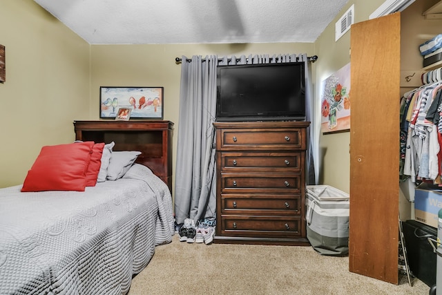 carpeted bedroom featuring visible vents and a textured ceiling