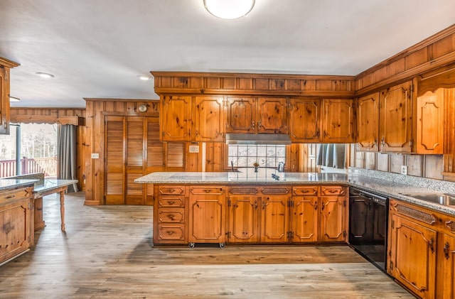 kitchen with light wood finished floors, wood walls, dishwasher, ornamental molding, and brown cabinets