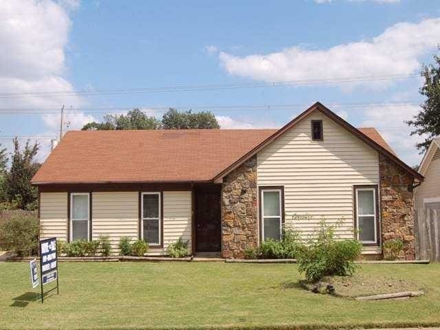 single story home featuring stone siding and a front lawn