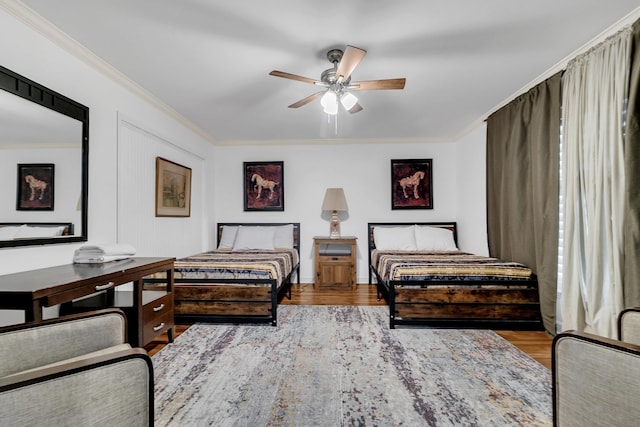 bedroom featuring crown molding, ceiling fan, and wood finished floors