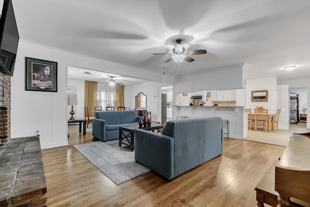 living room with light wood finished floors and a ceiling fan