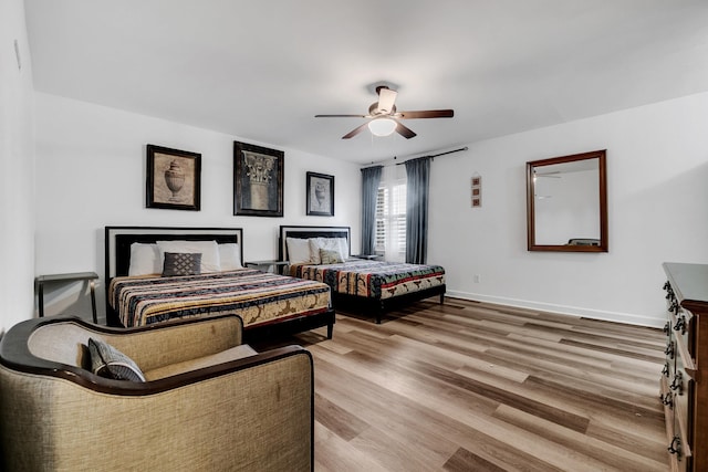 bedroom with ceiling fan, baseboards, and wood finished floors